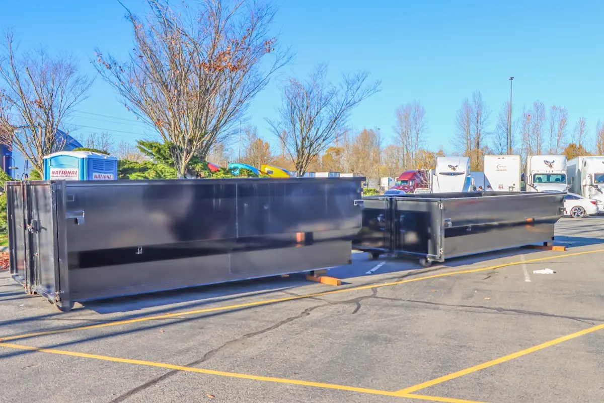 Professional dumpster rental service with roll-off container on residential driveway in Central Point